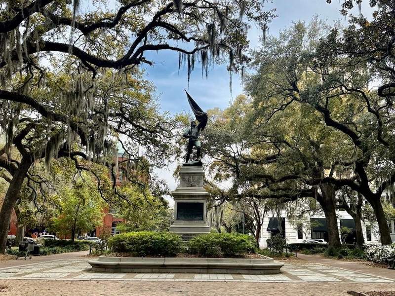 Madison Square with a center monument surrounded by oak trees dripping with spanish moss. 