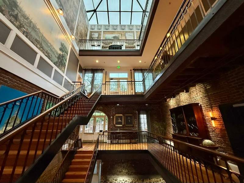 Multi story River Street Inn with staircases, brick and stone walls and artwork