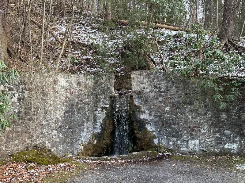 Water flowing over a wall of rocks. 