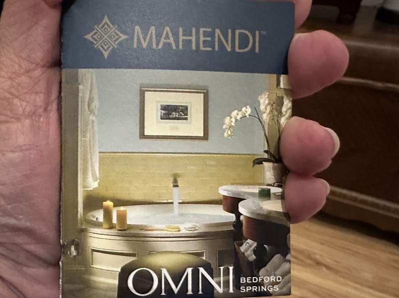 Someone holding a poscard with a photo of a bathtub. 