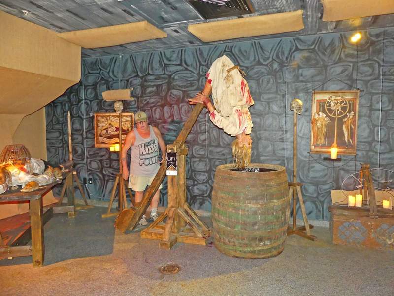 A museum exhibit at the Medieval Torture Museum in St. Augustine featuring a historical recreation of an interrogation scene with realistic figures.