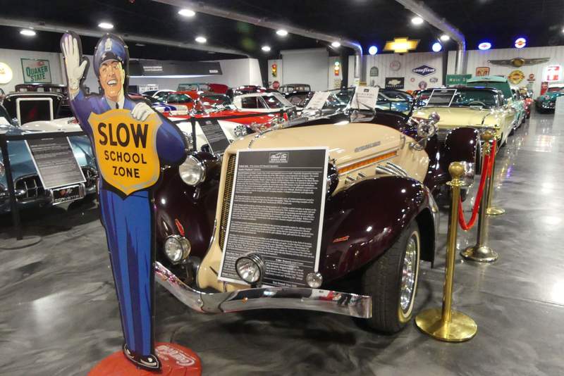 A row of brightly colored vintage American classic cars and trucks inside the 30,000-square-foot Ancient City Classic Car Museum.