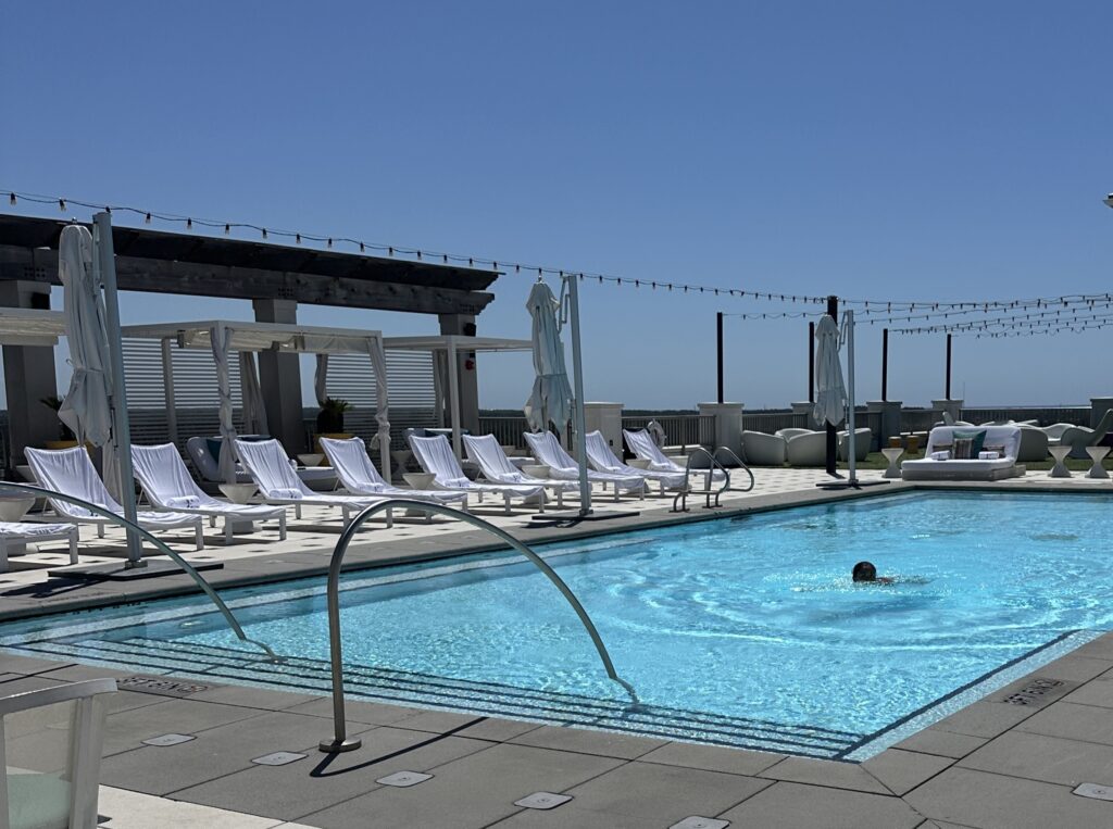 Man swimming in Ara rooftop pool at the Hotel Effie Sandestin Autograph Collection hotel in Destin, FL