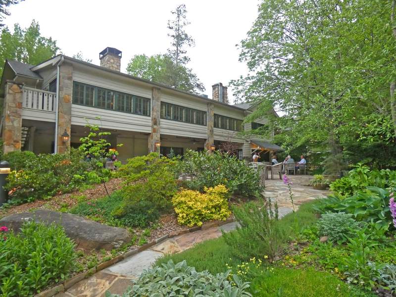 A two story building with a patio and a garden.