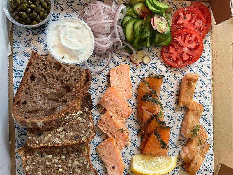 Lunch plate of cured fish, bread, and condiments.