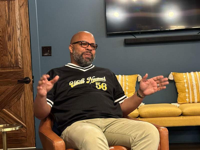 A man sitting in a chair talking.