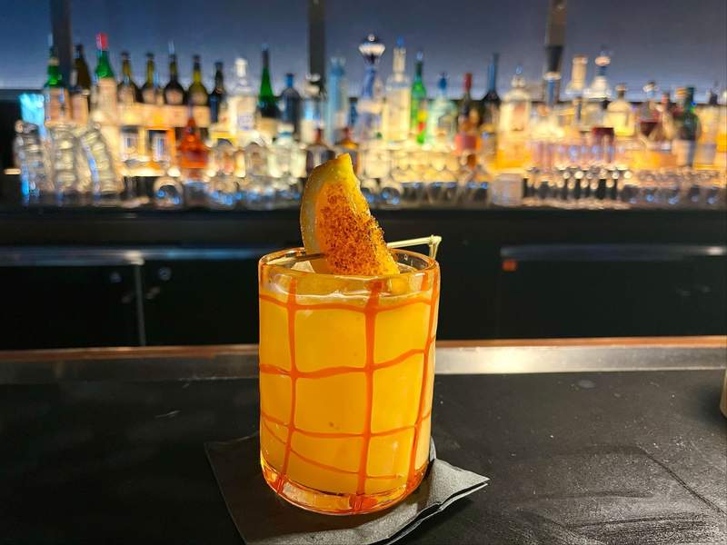 A bright orange cocktail with a caramelized orange sits on the bar at Todd English's bluezoo at the Dolphin hotel. 