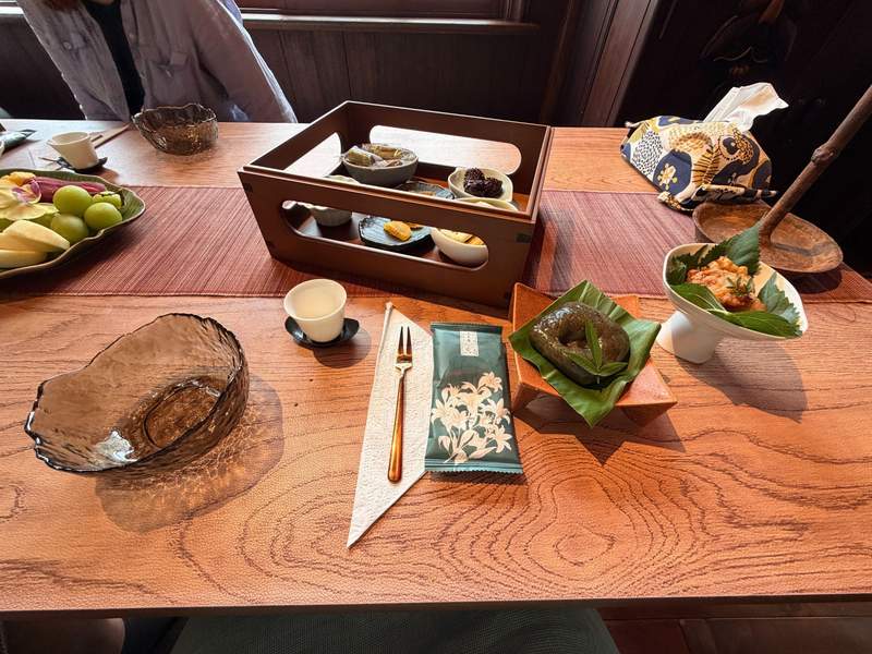 Beautiful wooden table with traditional tea cups, fresh fruit and a variety of food.