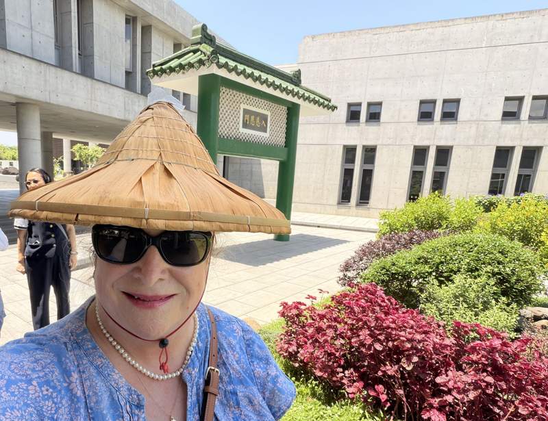Women wearing a traditional Taiwanese hat at a temple.