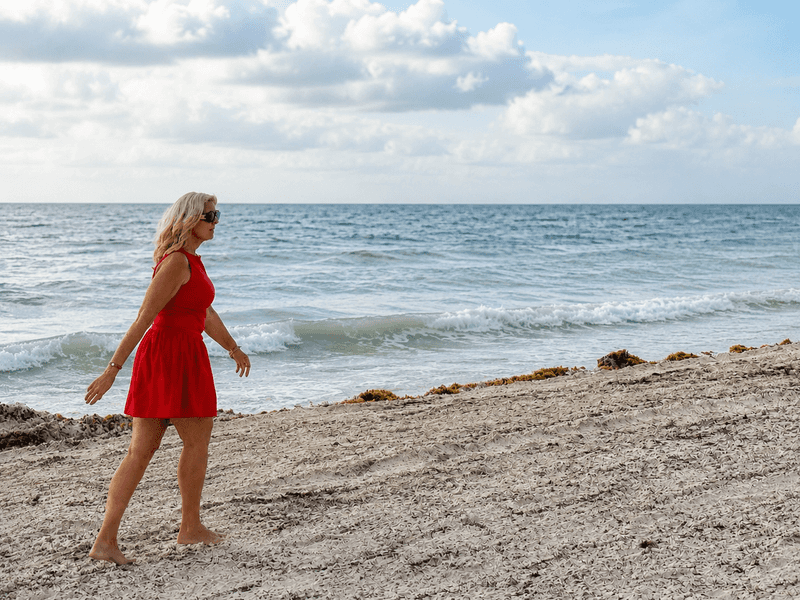 Woman walking barefoot along the beach at Sandos Cancun, a Cancun all inclusive adults only resort in Cancun’s Hotel Zone.