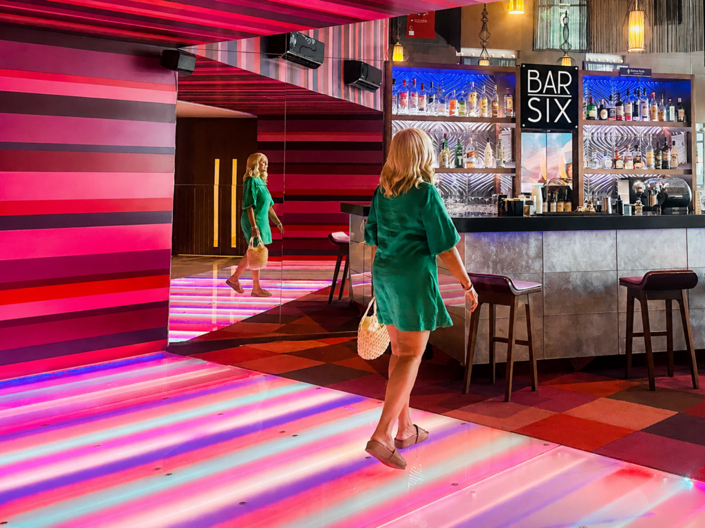 Woman walking through the colorful Bar Six lounge at Sandos Cancun, a Cancun all inclusive adults only resort in Cancun’s Hotel Zone