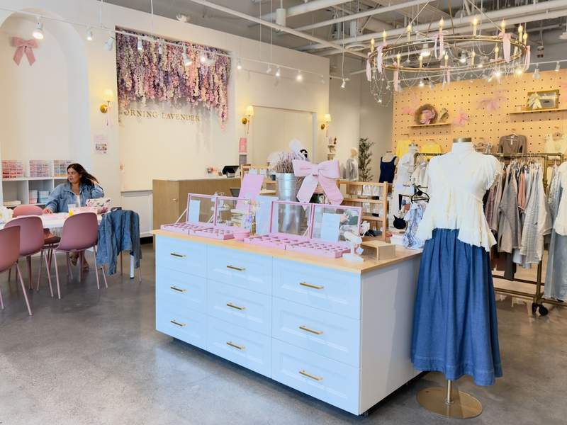 The entrance to a pink and very feminine themed retail store that sells charm bracelets and clothing.