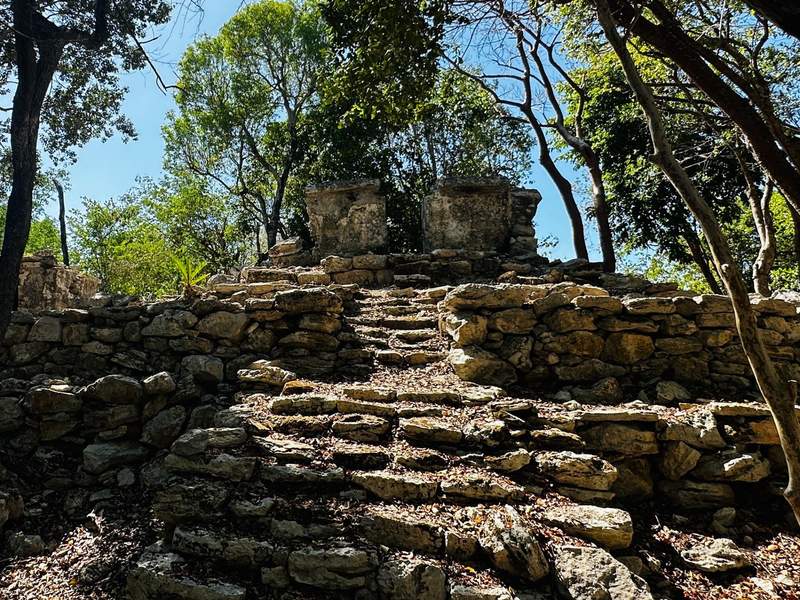 Ancient Mayan ruins surrounded by jungle at Sandos Caracol Nature Resort in Playa del Carmen Mexico.