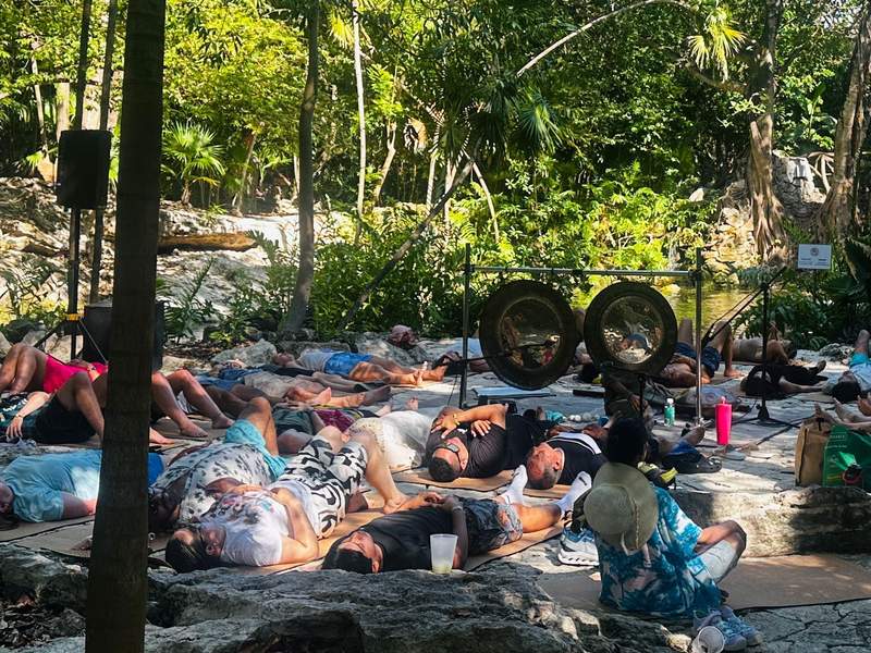Guests participating in a sound healing session surrounded by jungle and cenotes at Sandos Caracol Nature Resort in Playa del Carmen Mexico.