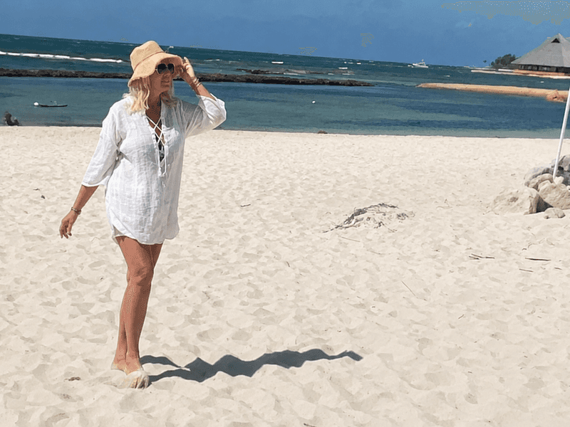 Woman walking along the beach at Sandos Caracol Nature Resort in Playa del Carmen Mexico near the adults only section of the resort.
