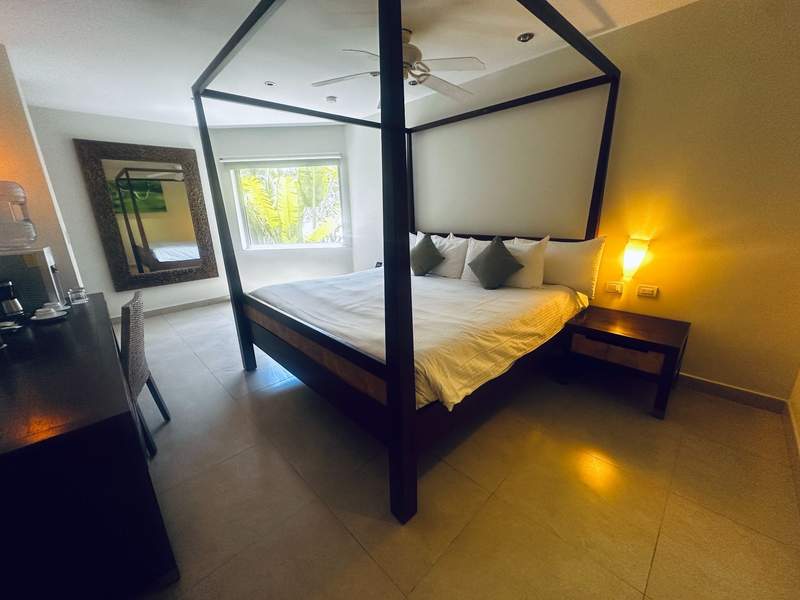King bedroom with canopy bed at Sandos Caracol Nature Resort in Playa del Carmen Mexico.