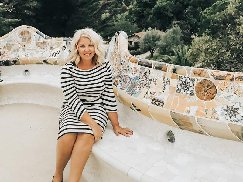 woman sitting at park guell in barcelona spain. 