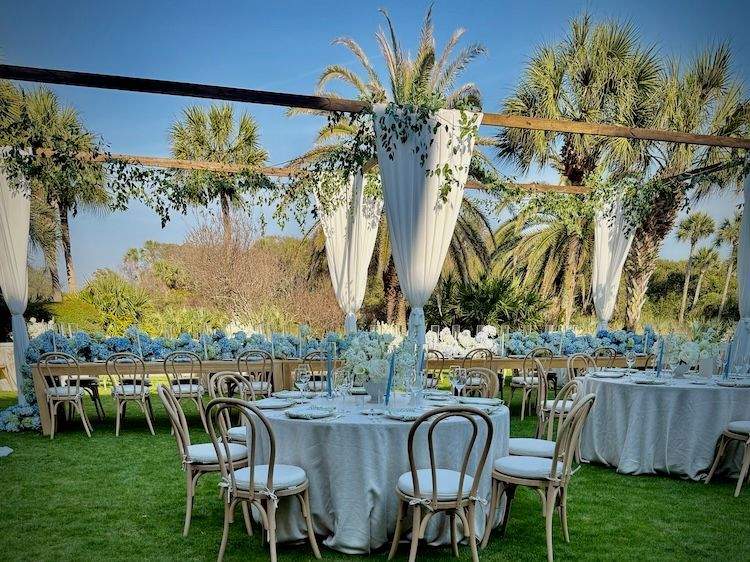 Wedding dinner tables set with floral arrangements, glassware and decorative accents ready for guests.