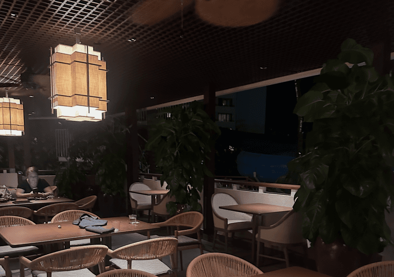 ShinSen Aruba dining room at night with geometric lanterns woven chairs and tropical plants at the Hyatt Regency Aruba