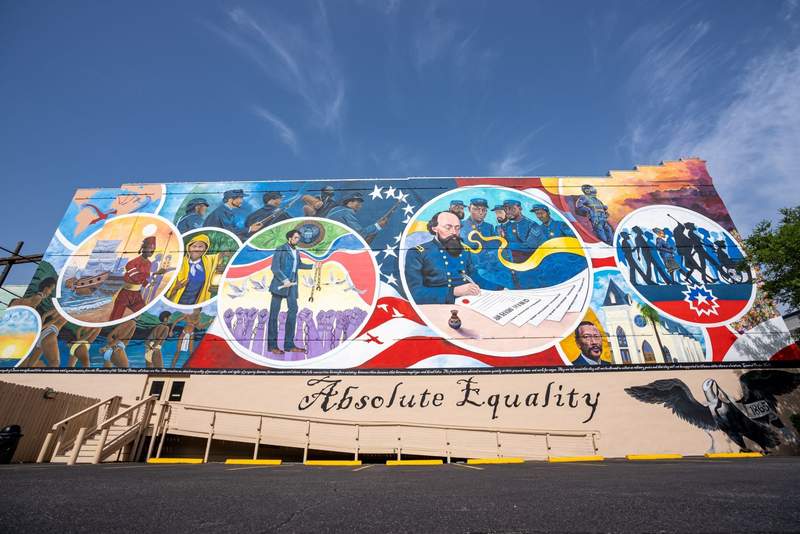 A colorful mural with historic images in circles and the words Absolute Equality underneath.