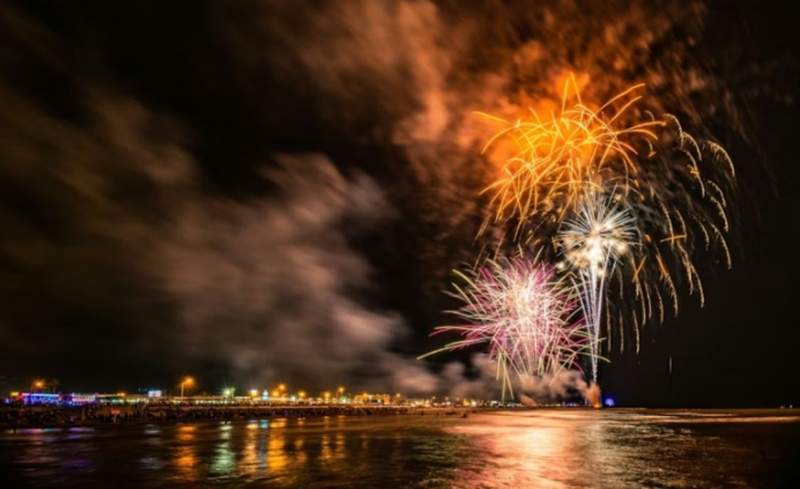 Fireworks in the sky reflecting in the water.