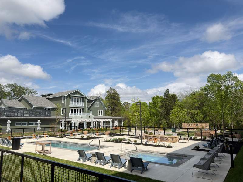 Exterior view of The Stonebreaker Hotel, a luxury boutique hotel on Markham Hill in Fayetteville Arkansas, surrounded by lush green trees, perfect for a girls' weekend getaway.