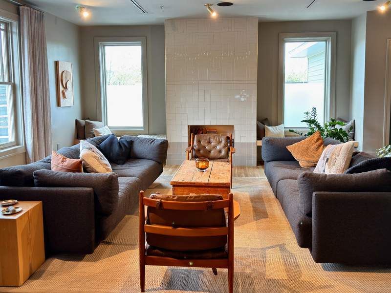 Social seating at the Stonebreaker Hotel's clubhouse in Fayetteville, AR with big couches, bright windows and a fireplace.