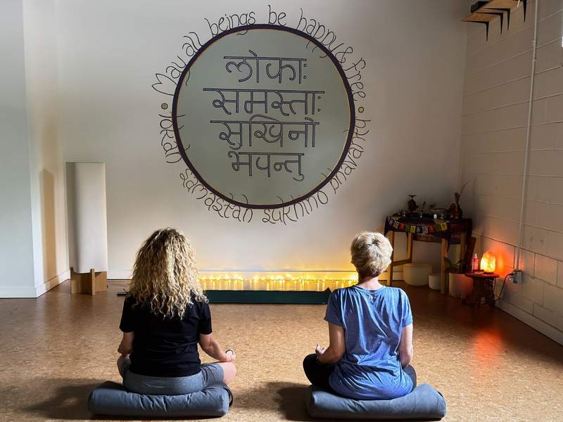 A peaceful morning group yoga class inside Trailside Yoga studio near the Razorback Greenway trail in Fayetteville Arkansas.