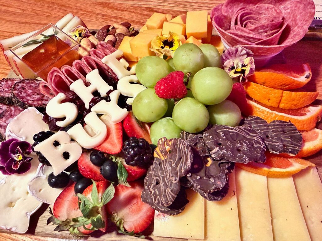 A beautifully curated charcuterie board featuring locally sourced meats, cheeses, and fruits paired with wine flights at Ozark Charcuterie & Wine Bar in Fayetteville AR