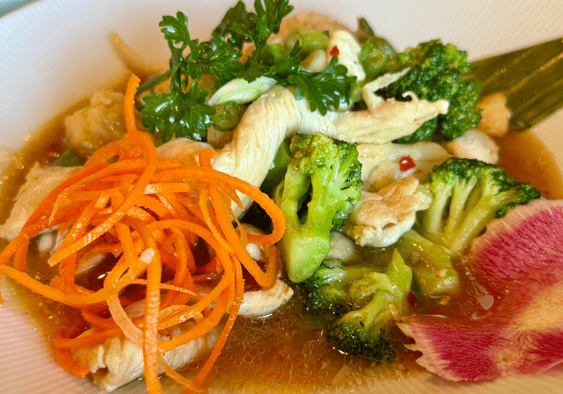 Thai chicken broth bowl with broccoli, shredded carrots, fresh herbs, and watermelon radish at Yum Yai Street Thai in Birmingham, Alabama