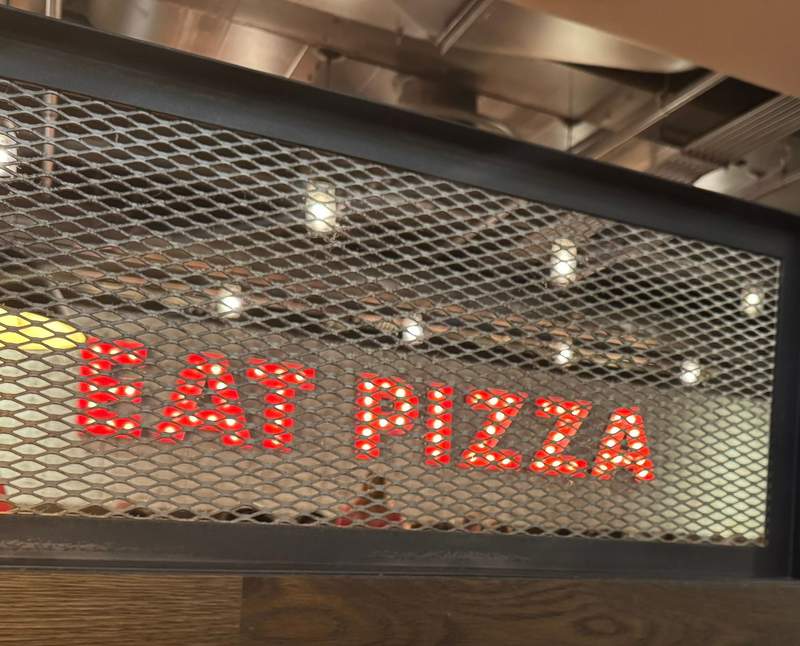“Eat Pizza” sign displayed inside Giordano's, capturing the casual and inviting atmosphere of the iconic Chicago deep dish pizza restaurant.