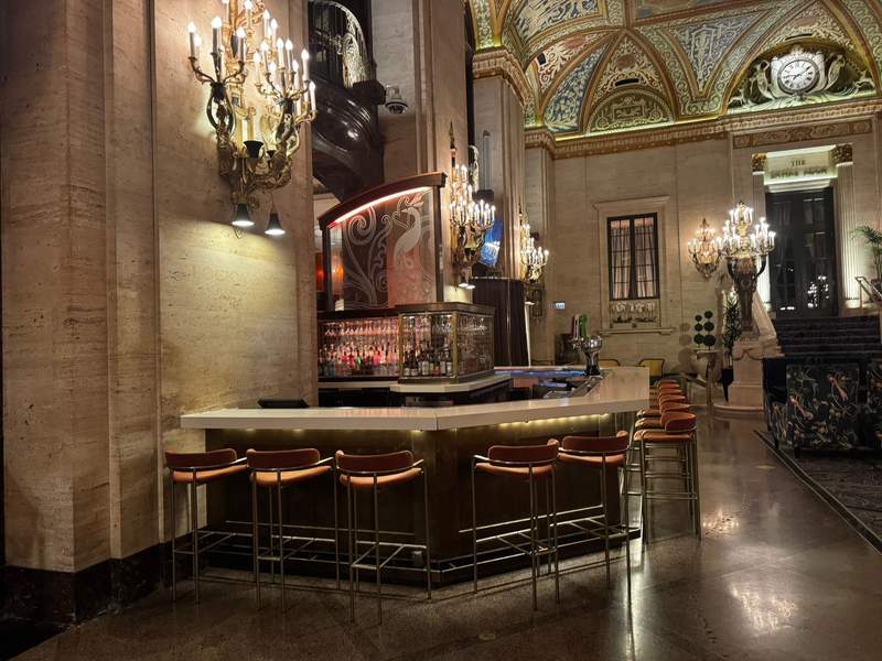 Interior view of the Lockwood Lobby Bar at the Palmer House Hilton, featuring an elegant, historic setting with warm lighting, classic architectural details. 