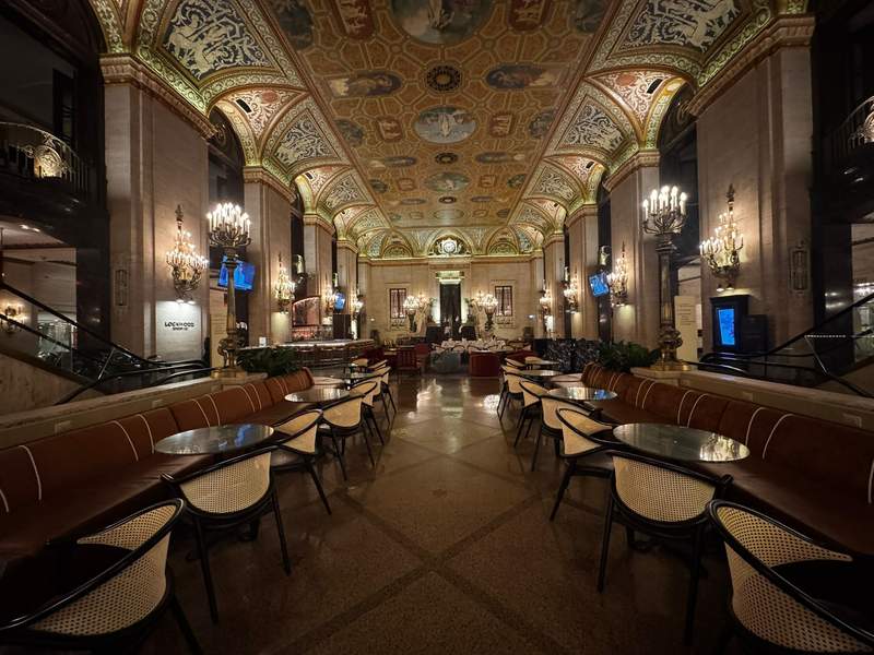 The stunning lobby of the Palmer House Hilton featuring elegant historic architecture, lively lobby bar, chandeliers, and ceiling fresco.
