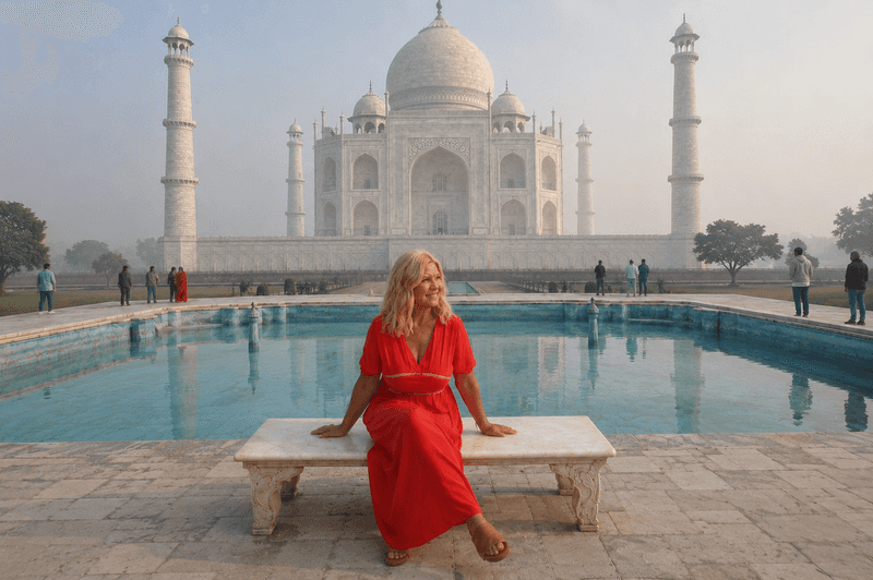 Woman sitting on a marble bench in front of the Taj Mahal with a reflecting pool and light morning fog in Agra, India.