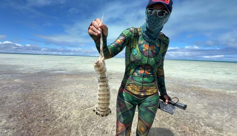 A person holding a large mantis shrimp