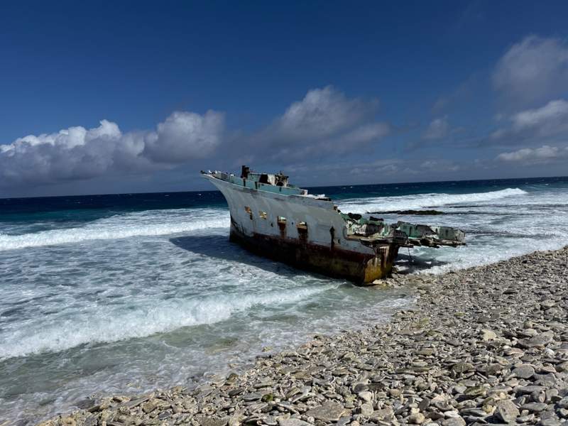 A shipwreck sitting on a coral beach
