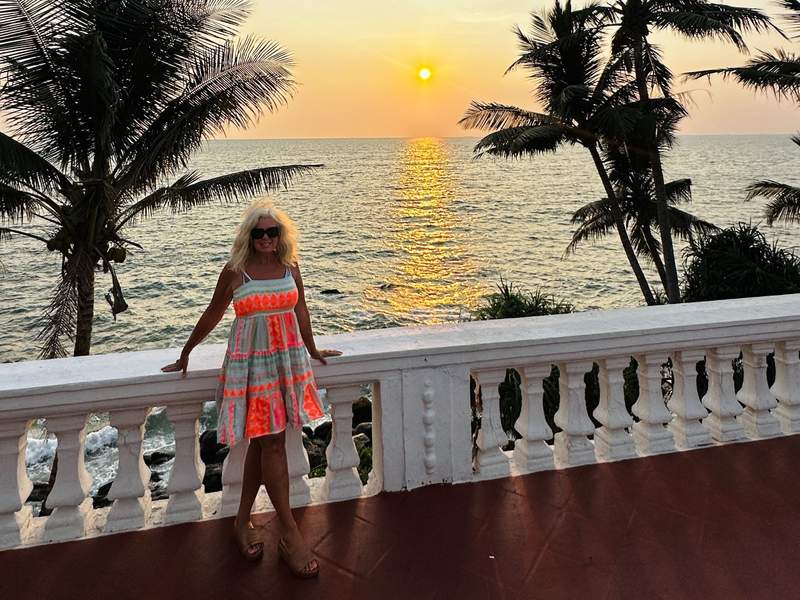 woman standing in front of sunset sky.