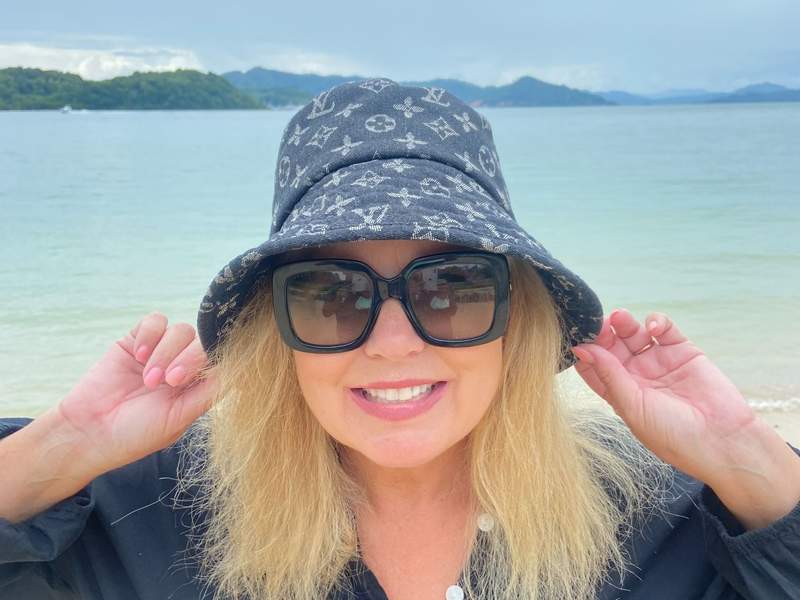 close up of woman on the beach smiling.