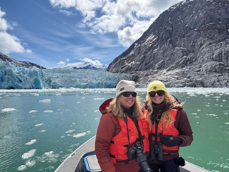 Two women on a skiff near Dawes Glacier during an eco cruise with The Boat Company