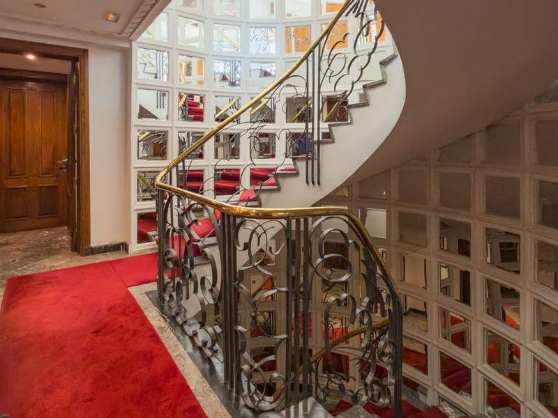 A spiral staircase with red carpet