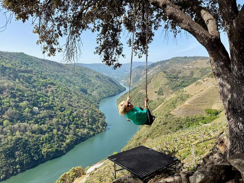 Author swinging on a tree swing overlooking the beautiful Sil River at Adega Terra Brava winery.