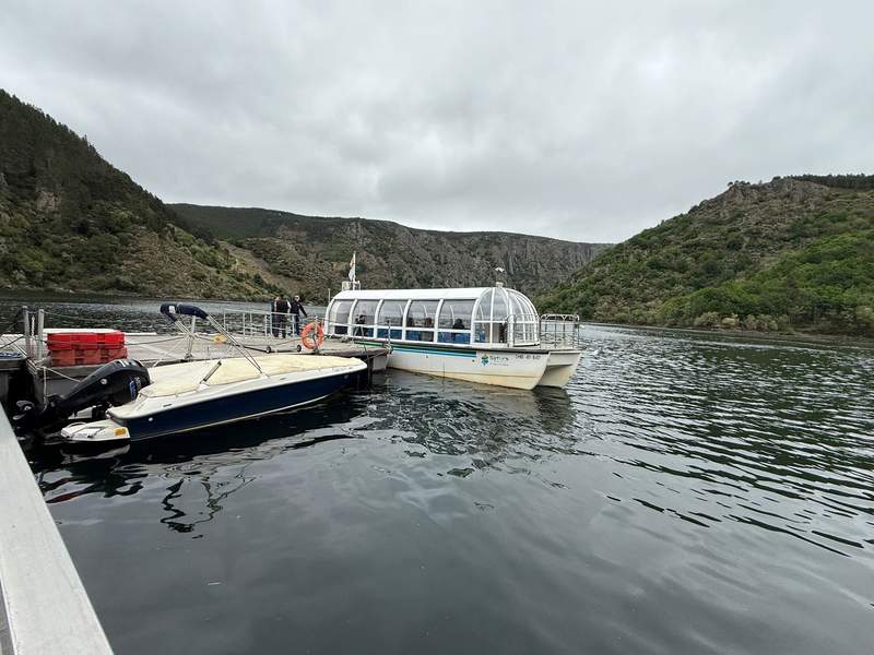 A catamaran boat pulled up to a dock.