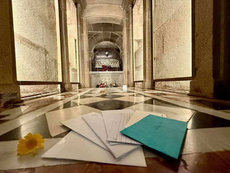 Letters and flowers on the floor before a crypt tomb in the Cathedral of Santiago de Compostela.