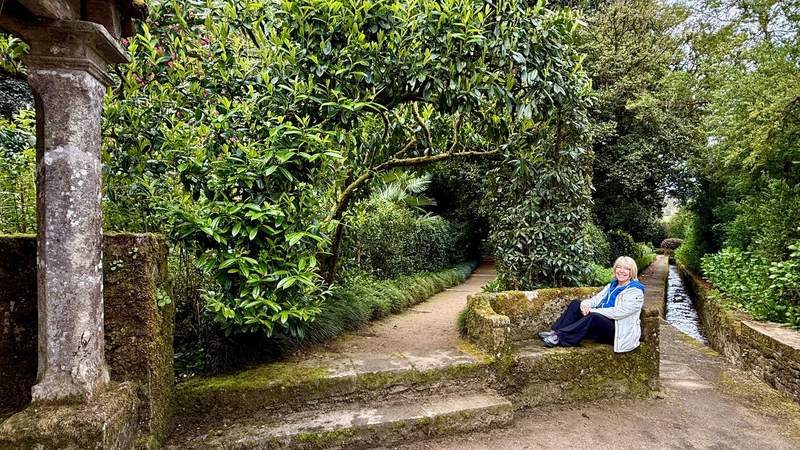 Author resting on a stone bench in n the Pazo de Oca gardens.