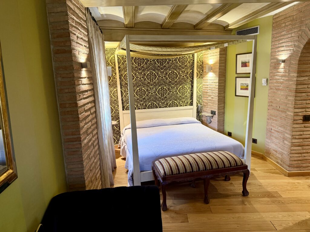 Interior of a hotel bedroom with lime green walls and a canopy bed
