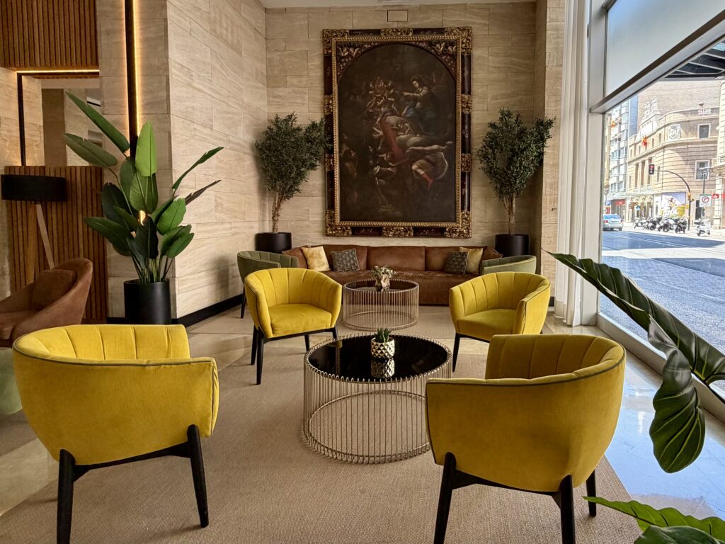 Gold barrel chairs surrounding a table in the Hotel Silken Reino lobby in Zaragoza, Spain.