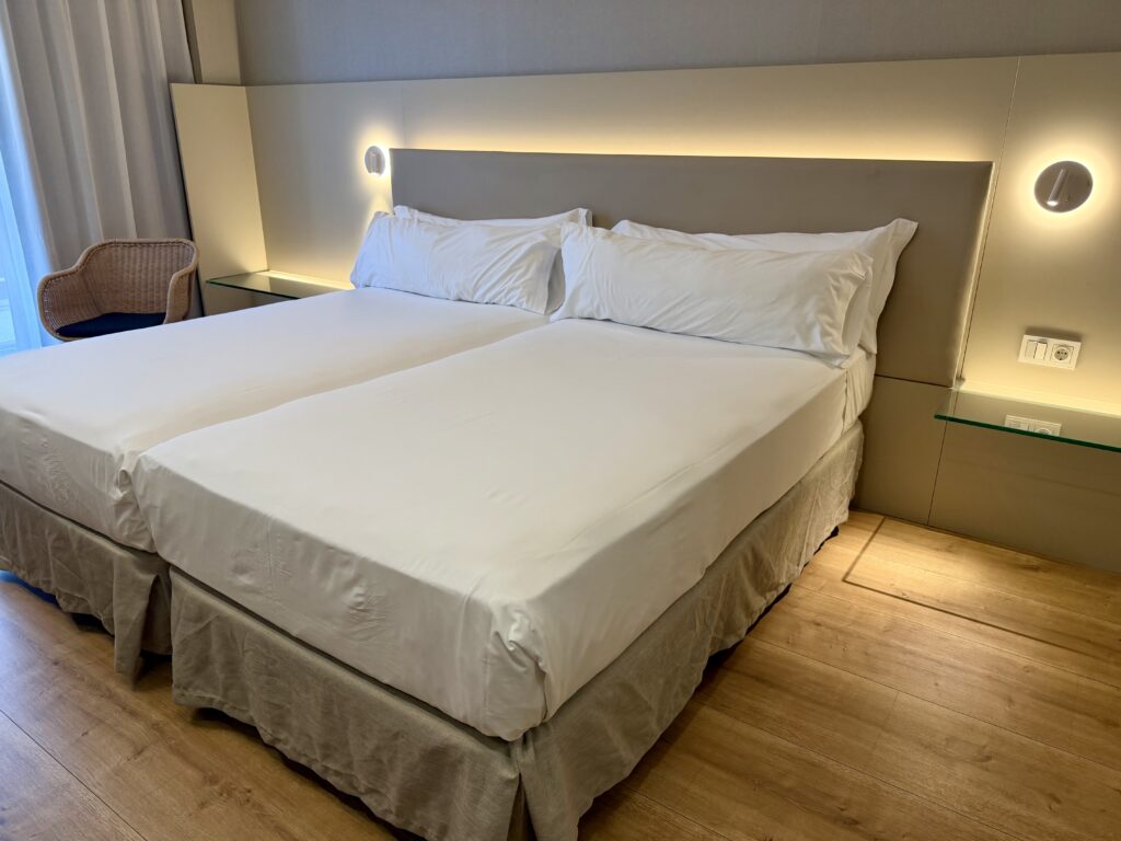 Double bed in simple hotel room in Zaragoza, Aragon.