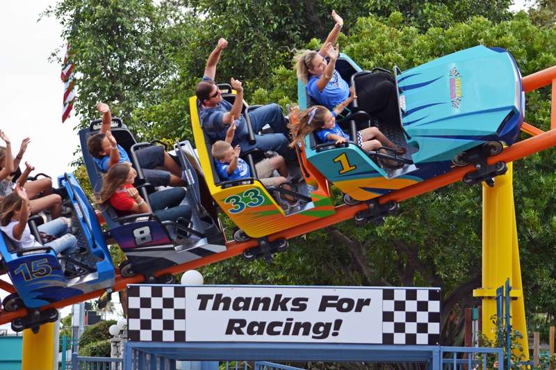 Kids and parents on a colorful mini roller coaster at Adventure City in Anaheim, CA.