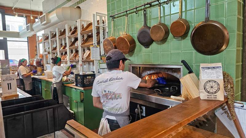 A man working in front of a stone oven at a restaurant