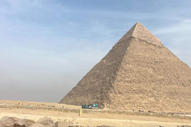 A striking solo view of a single Egyptian pyramid rising up from the vast golden sands of the desert.